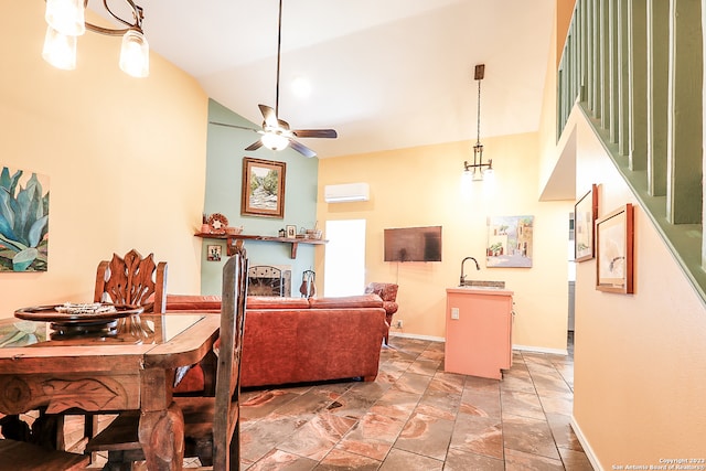 living room with an AC wall unit, ceiling fan with notable chandelier, light tile flooring, high vaulted ceiling, and sink