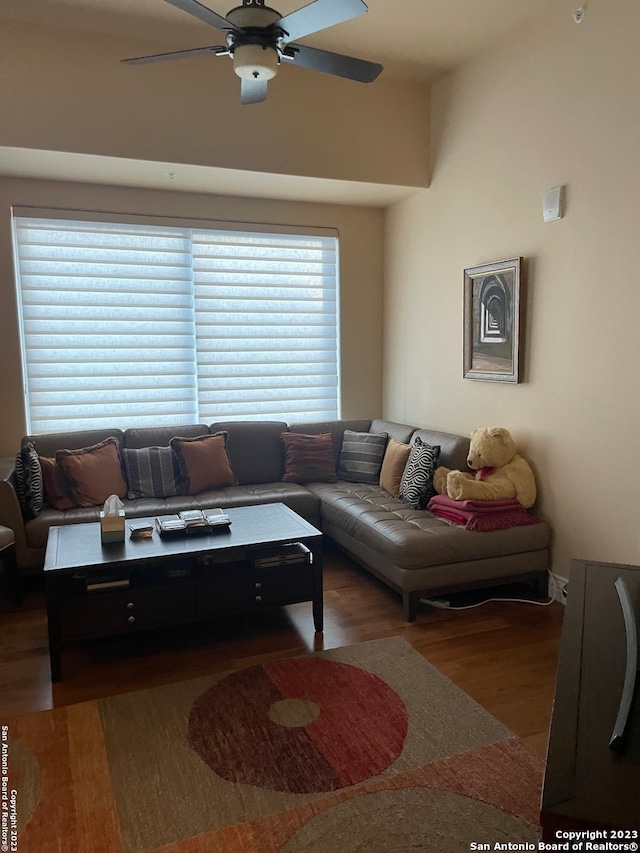 living room with dark wood-type flooring and ceiling fan