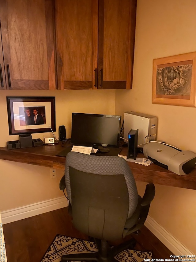 home office featuring built in desk and hardwood / wood-style flooring