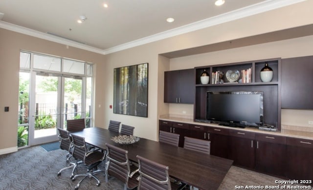 dining room featuring ornamental molding and dark carpet