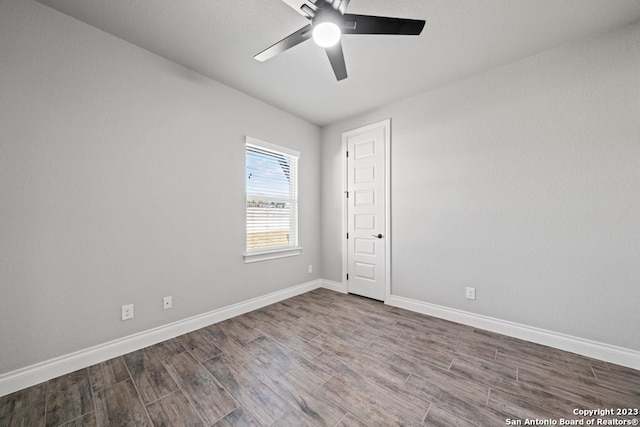 empty room with ceiling fan and dark wood-type flooring