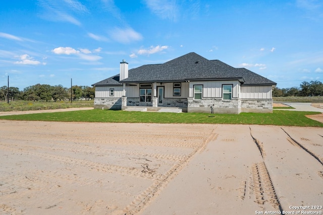 view of front facade featuring a front yard and covered porch