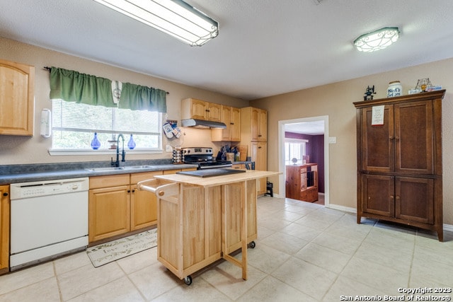 kitchen featuring white dishwasher, a kitchen island, and light tile floors