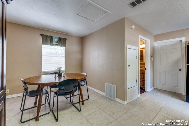 dining area with light tile floors and a textured ceiling