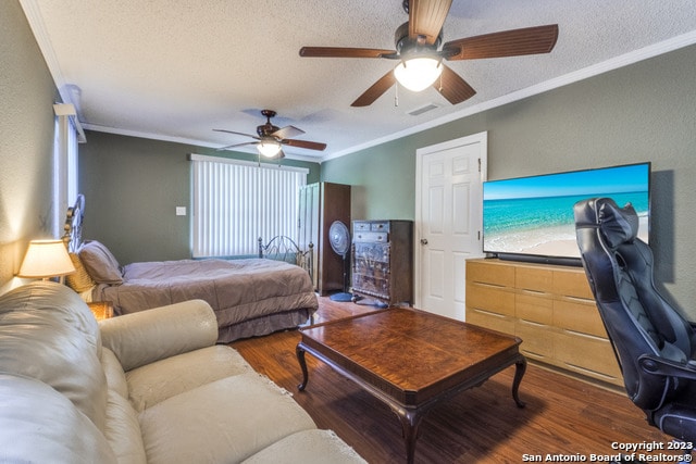 bedroom with ceiling fan, dark wood-type flooring, and ornamental molding