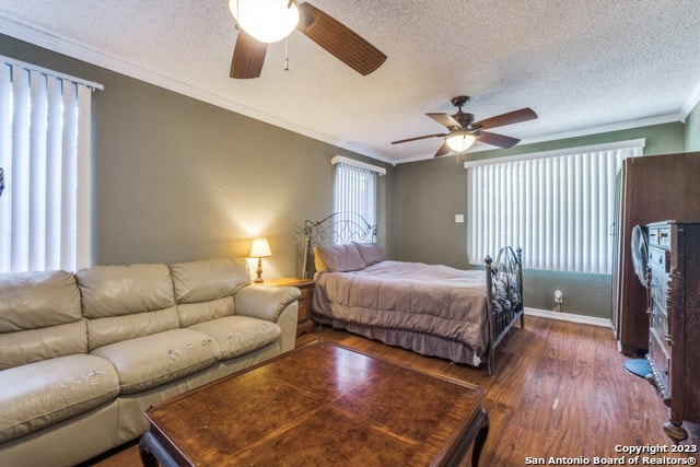 bedroom with a textured ceiling, dark hardwood / wood-style floors, ceiling fan, and ornamental molding