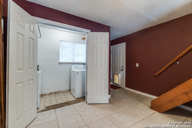 laundry area featuring washer / clothes dryer and light tile floors