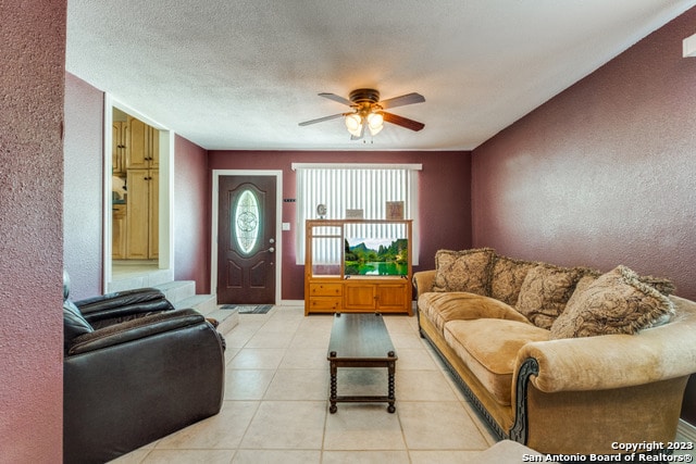 tiled living room featuring ceiling fan and a textured ceiling