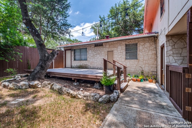 rear view of house featuring a wooden deck