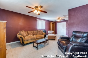 living room with light tile floors and ceiling fan