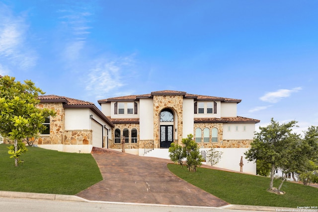 mediterranean / spanish-style house with french doors and a front lawn