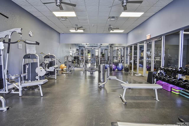 workout area with a paneled ceiling and ceiling fan