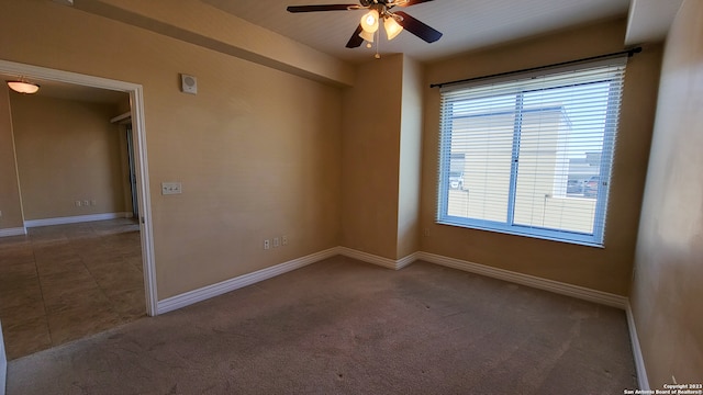 carpeted spare room featuring ceiling fan