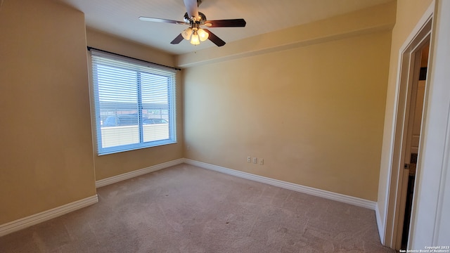 spare room with ceiling fan and light carpet