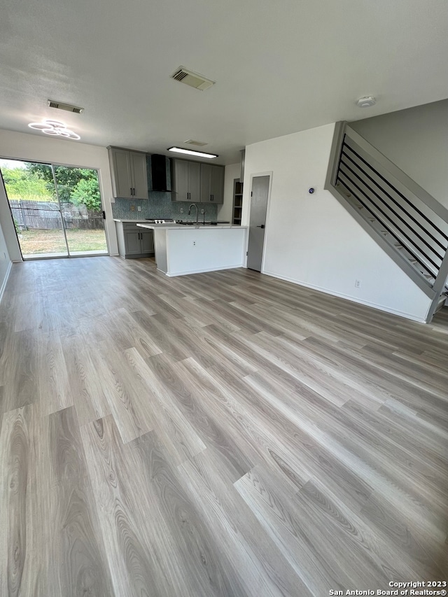 unfurnished living room with light hardwood / wood-style floors and sink