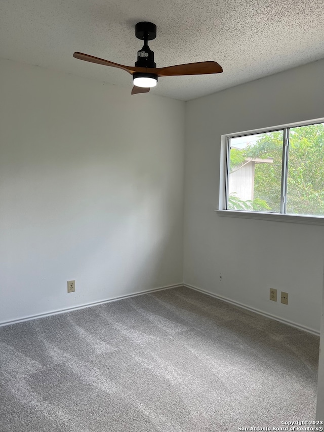 spare room featuring carpet floors, a textured ceiling, and ceiling fan