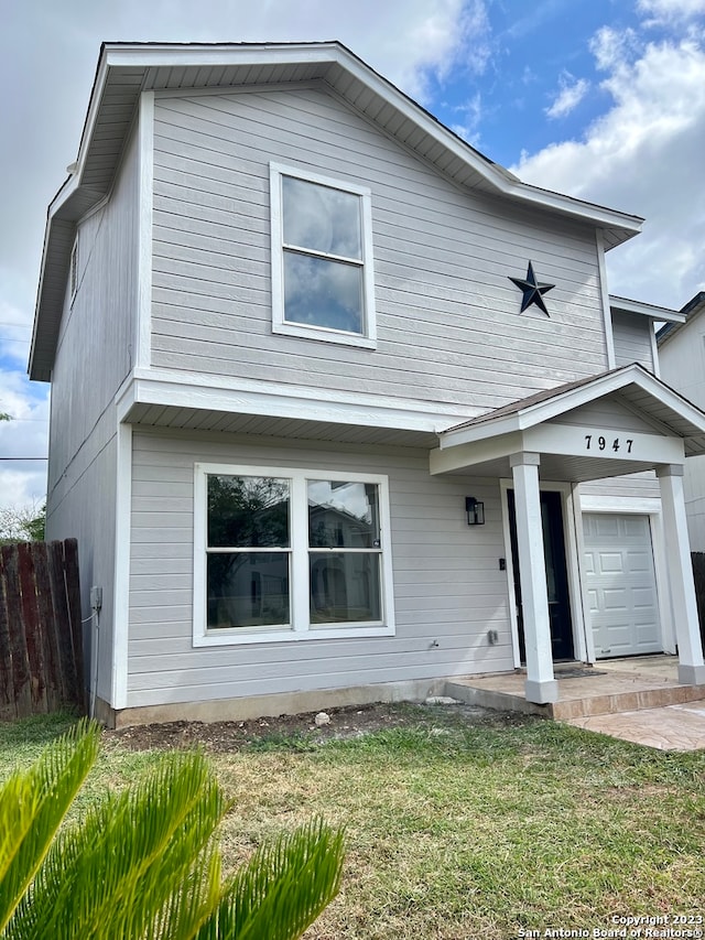 view of front of property with a front yard and a garage