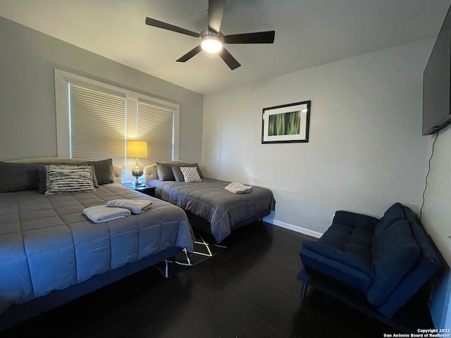 bedroom with dark hardwood / wood-style floors and ceiling fan