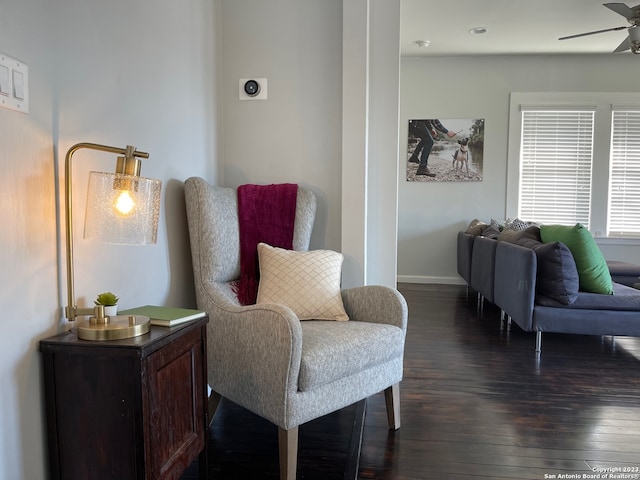 living area with ceiling fan and dark hardwood / wood-style floors