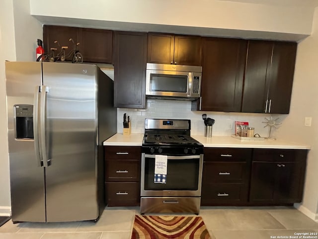 kitchen with light tile flooring, backsplash, dark brown cabinetry, and stainless steel appliances