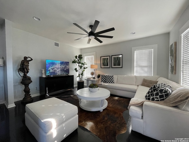 living room with ceiling fan and dark wood-type flooring