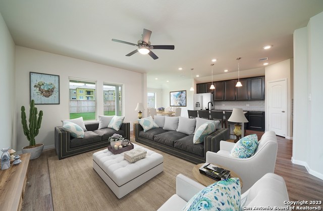 living room featuring ceiling fan and light wood-type flooring