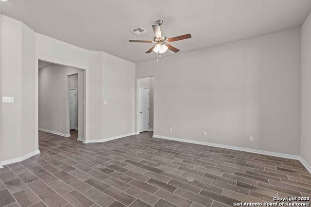 unfurnished room with ceiling fan and dark wood-type flooring