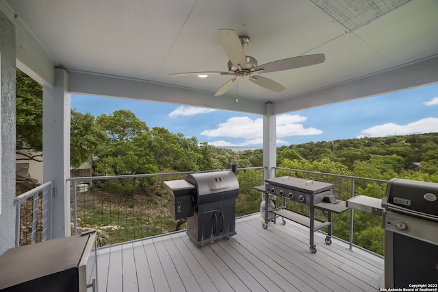 wooden deck with area for grilling and ceiling fan