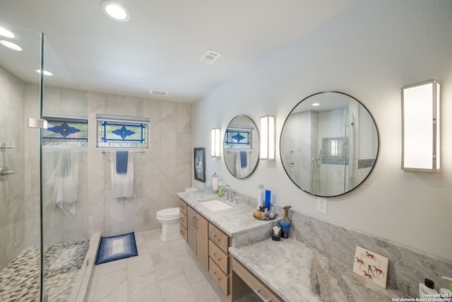 bathroom featuring toilet, a shower with shower door, oversized vanity, tile walls, and tile flooring