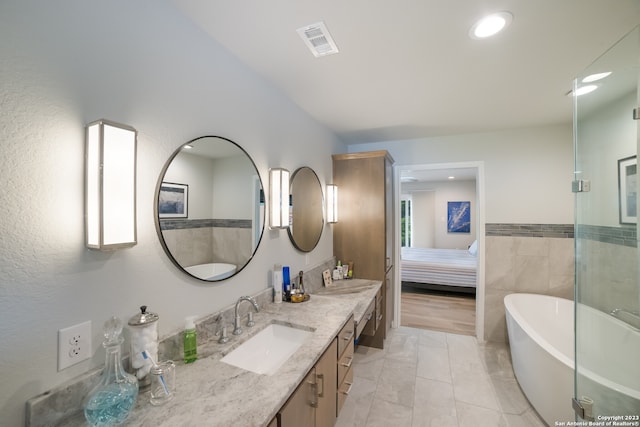 bathroom with a washtub, double sink, tile floors, and oversized vanity