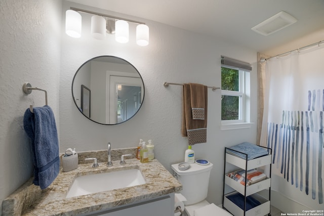 bathroom featuring toilet and large vanity