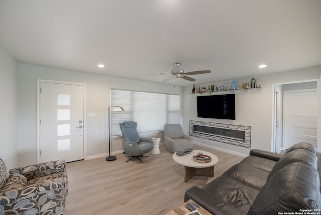 living room with ceiling fan and light hardwood / wood-style flooring