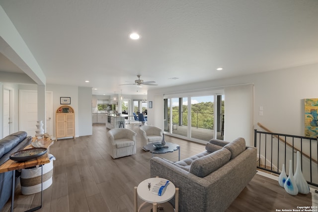 living room with ceiling fan and dark wood-type flooring