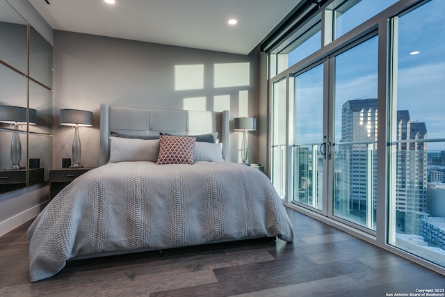 bedroom with access to outside and dark hardwood / wood-style floors