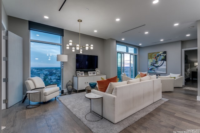 living room with a wall of windows, wood-type flooring, and an inviting chandelier