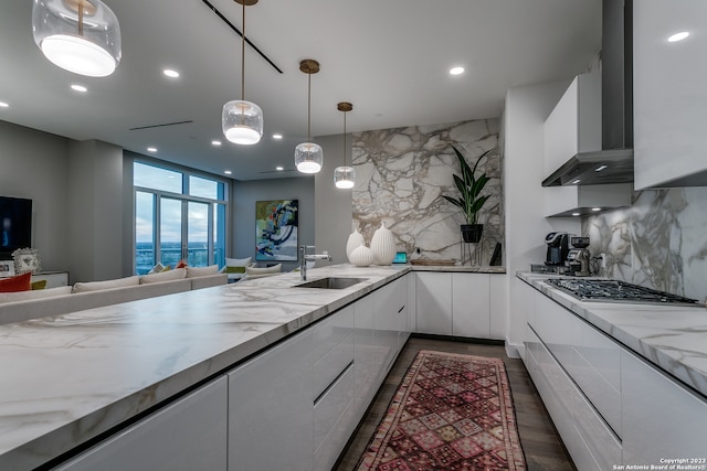 kitchen with white cabinets, backsplash, sink, and stainless steel gas stovetop