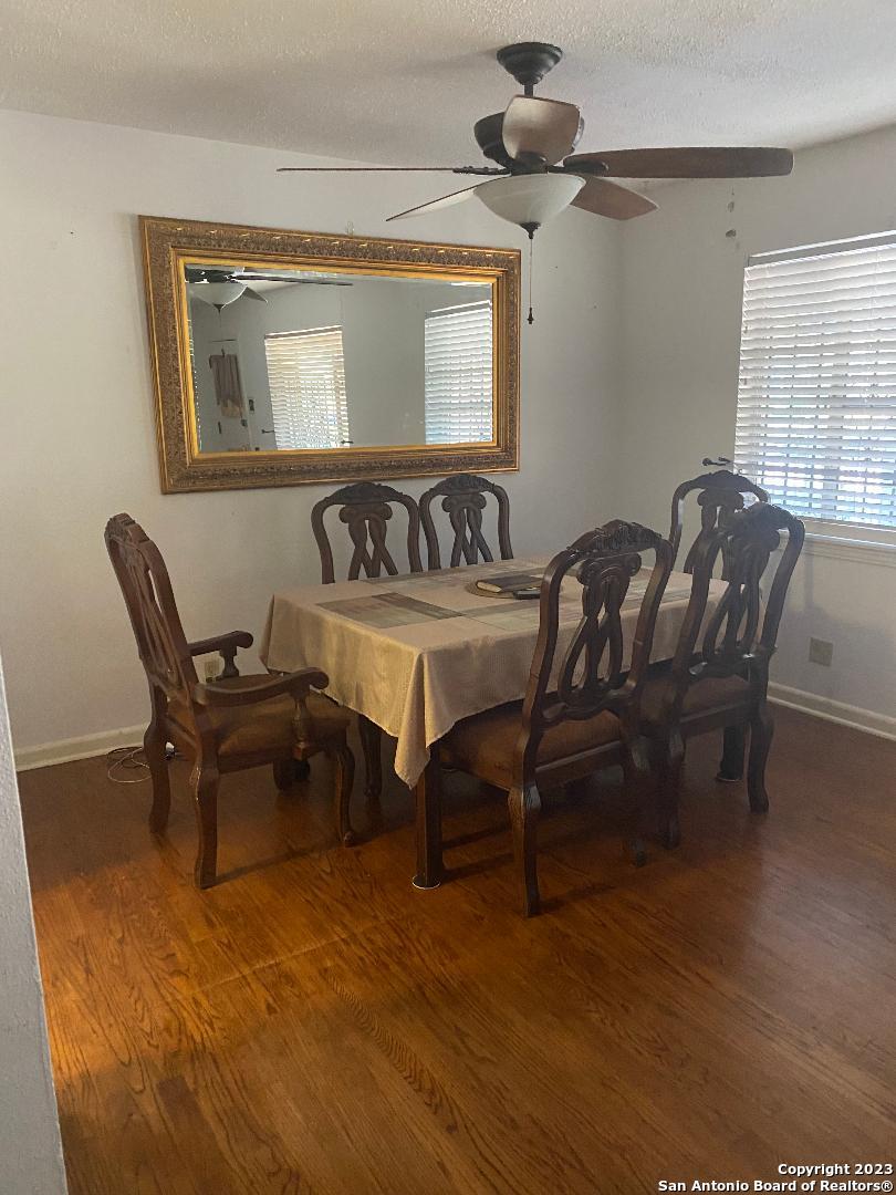 dining room featuring ceiling fan, dark hardwood / wood-style floors, and a textured ceiling