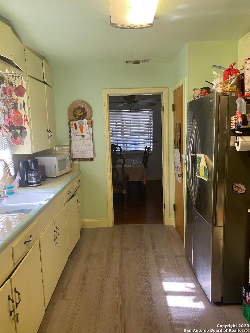 kitchen featuring stainless steel refrigerator, light hardwood / wood-style flooring, and sink