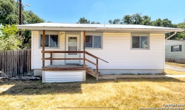 rear view of property featuring a yard