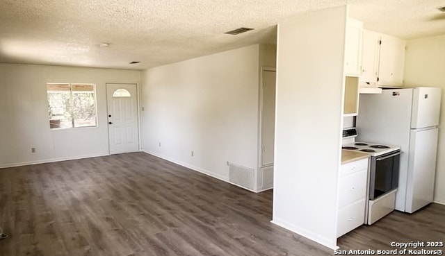 kitchen featuring white cabinets, white appliances, a textured ceiling, and dark hardwood / wood-style flooring