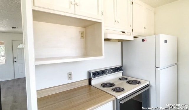 kitchen featuring white appliances, white cabinets, and hardwood / wood-style floors
