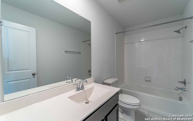 full bathroom featuring toilet, tile floors, tiled shower / bath combo, and oversized vanity