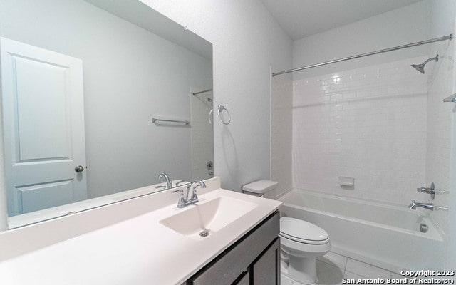 full bathroom with tile flooring, oversized vanity, toilet, and tiled shower / bath