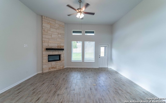 unfurnished living room featuring light hardwood / wood-style floors, a fireplace, and ceiling fan