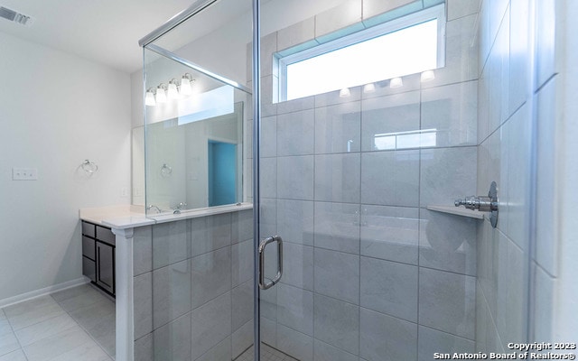 bathroom featuring tile floors, an enclosed shower, and vanity