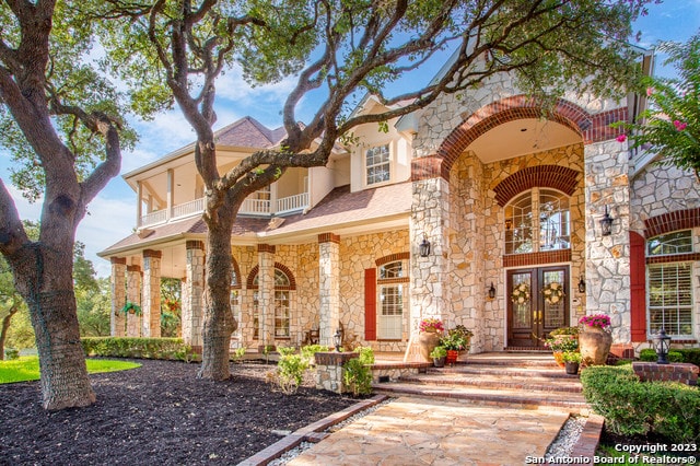 mediterranean / spanish-style house with a balcony and french doors