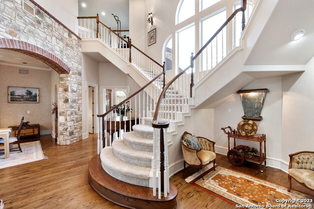 staircase featuring a high ceiling and dark hardwood / wood-style floors