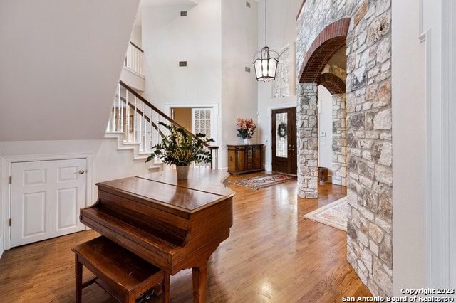 entrance foyer featuring a high ceiling, an inviting chandelier, and light hardwood / wood-style flooring