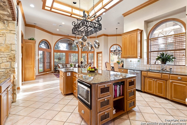 kitchen featuring tasteful backsplash, a center island with sink, a healthy amount of sunlight, and appliances with stainless steel finishes