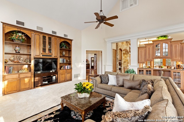 living room with high vaulted ceiling, ceiling fan, and carpet floors